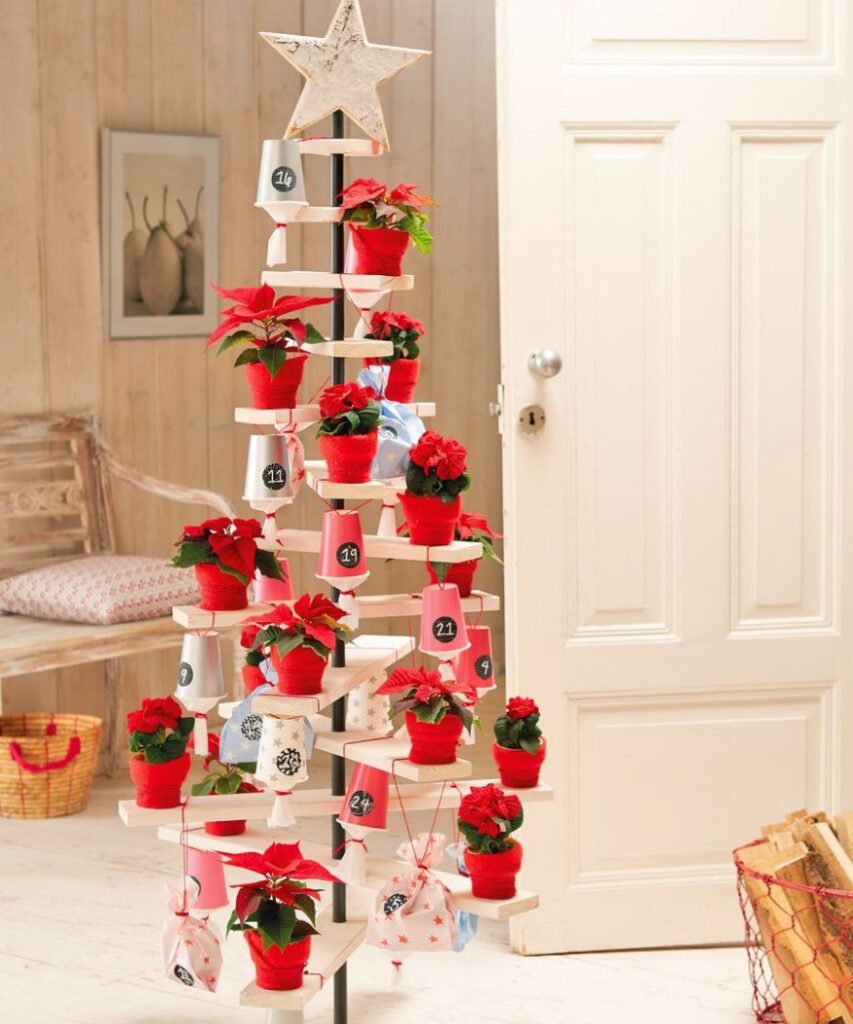 Креативна коледна елха, изработена от дървени летви, с мини коледни звезди и номерирани торбички, висящи от нея, за да се получи календар за Адвент 