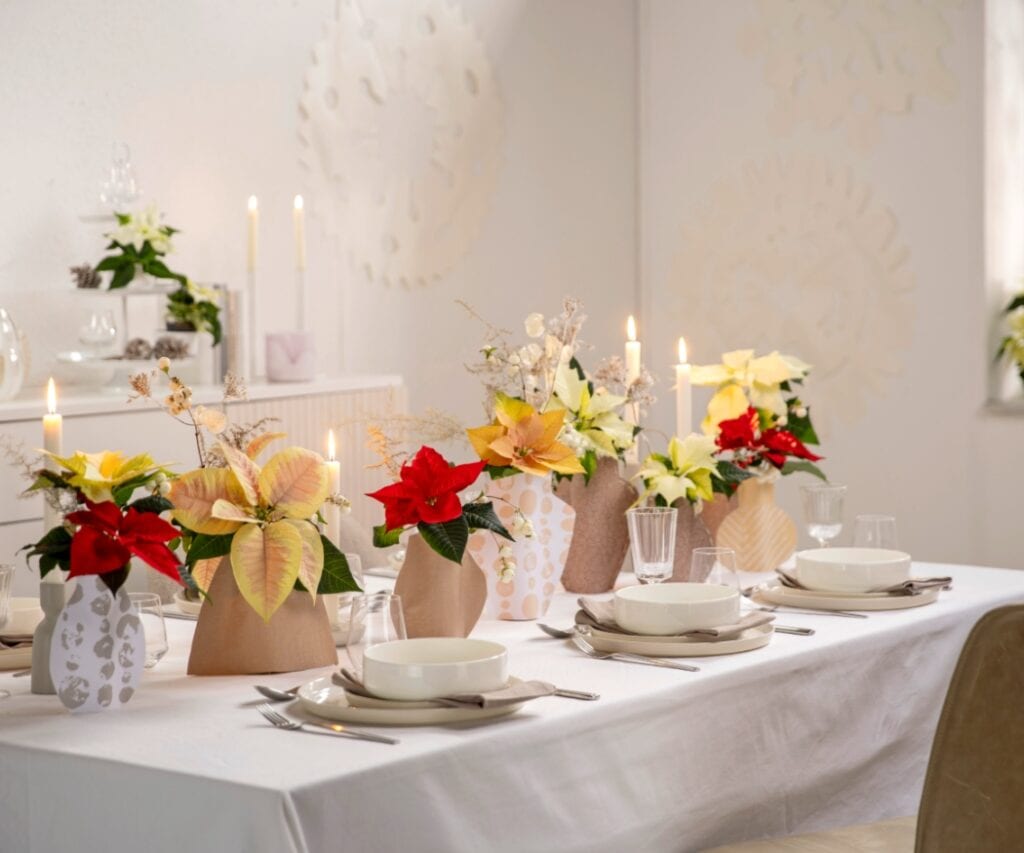Ein festlich gedeckter Tisch mit selbst gestalteten Upcycling-Vasen.
