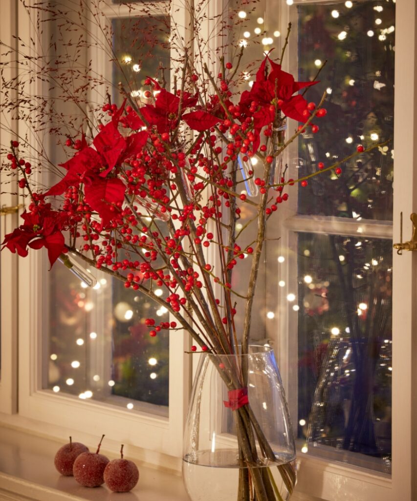 Bouquet natalizio moderno con Stelle di Natale rosse in provette, rami di ilex e graminacee 