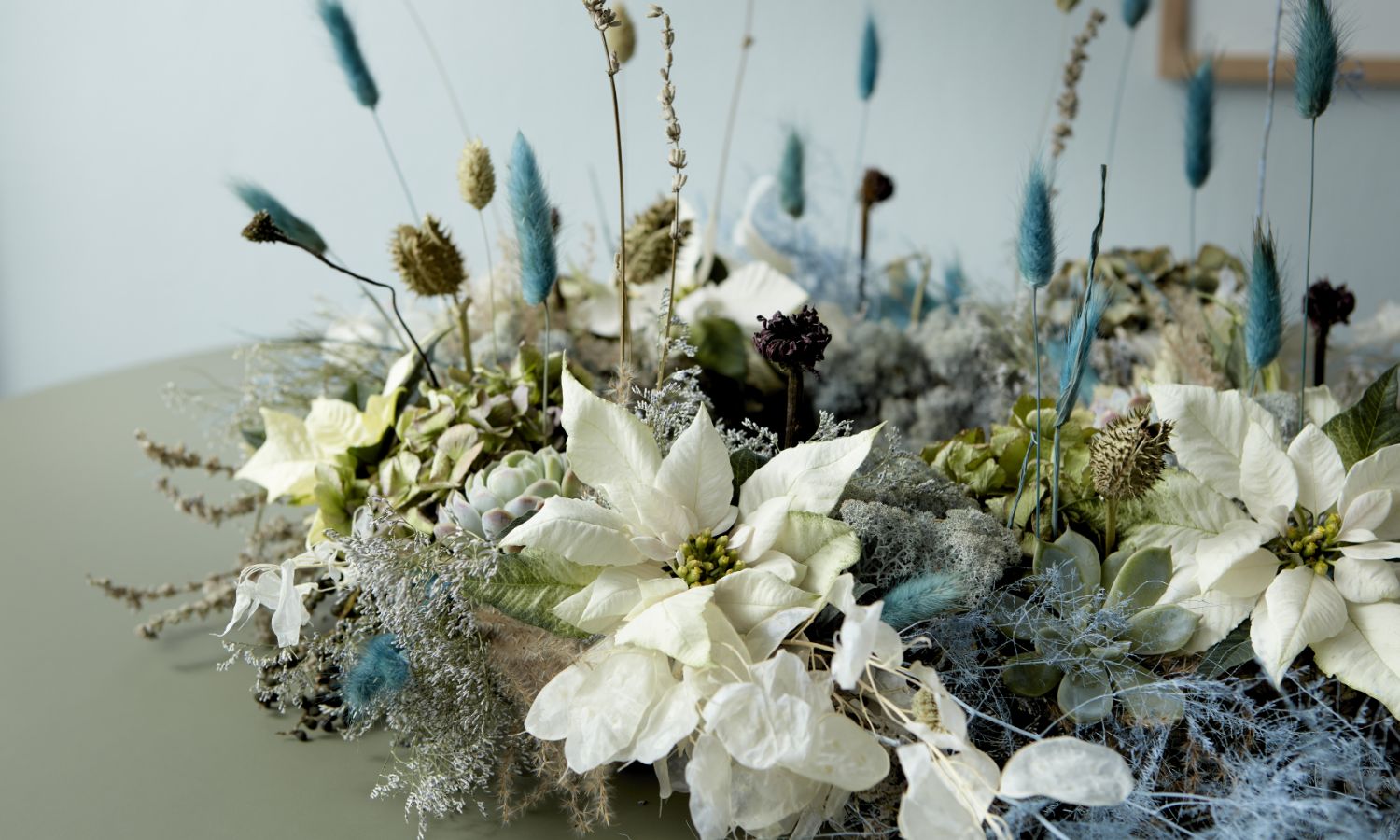 Floristische Tischdekoration mit weißen Weihnachtssternen